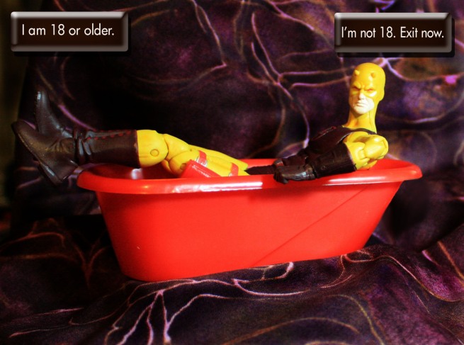 Daredevil, dressed in his yellow costume, reclines in a bathtub.